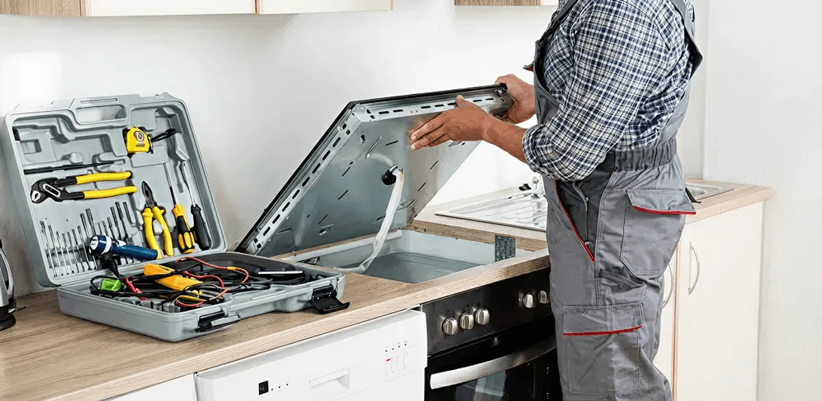 Handyman repairing a cooktop and checking wiring connections in Fargo, ND