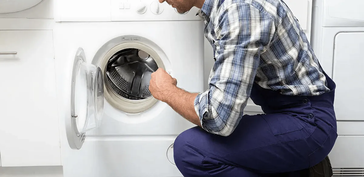 Handyman inspecting a dryer drum and internal parts for repair in Fargo, ND