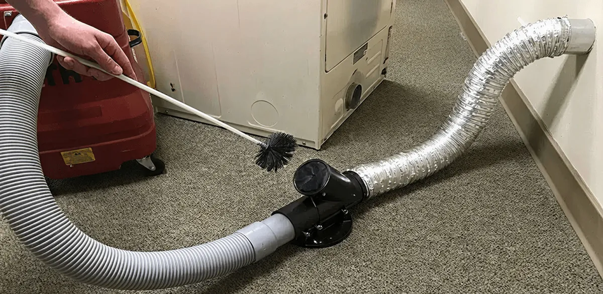 Dryer vent cleaning service removing lint from a dryer duct connection in Fargo, ND