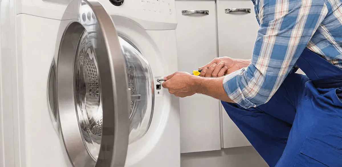 Handyman repairing a clothes dryer and checking electrical connections in Fargo, ND