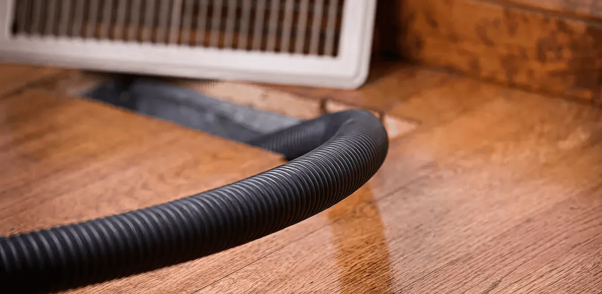 Air duct cleaning hose inserted into a floor vent for ductwork cleaning in Fargo, ND